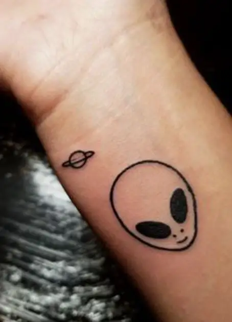 small alien tattoo and a tiny little planet