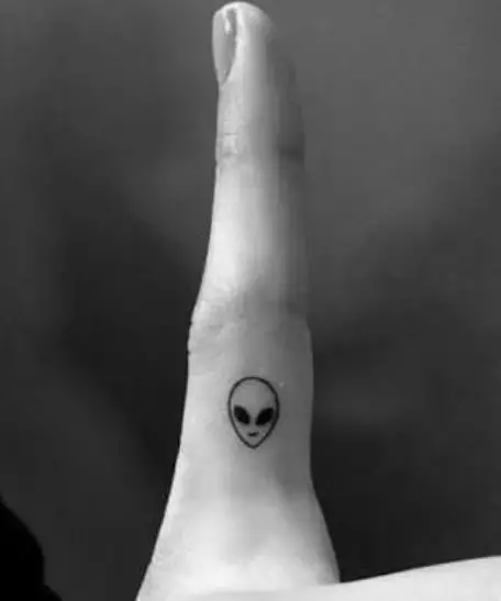 small alien tattoo on a finger