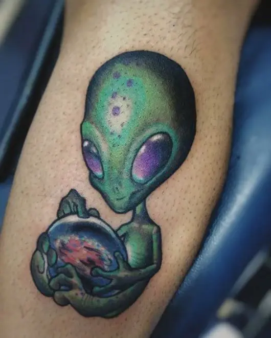green celestial alien tattoo on leg