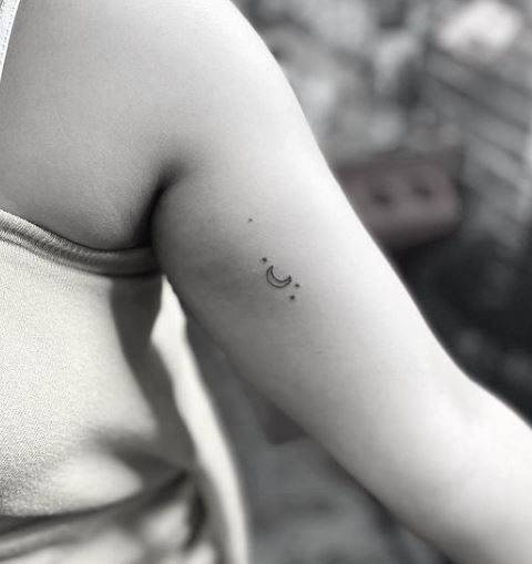 small moon and star tattoo on the arm