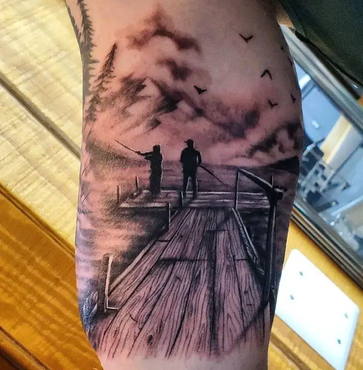 tattoo of two people fishing on a pier