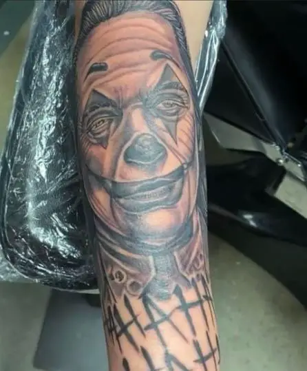 Black and grey Joker tattoo on the arm