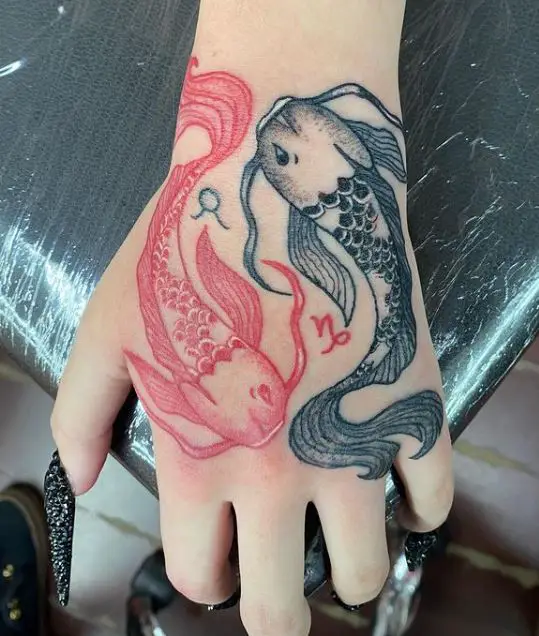 black and red koi fish tattoo on the hand