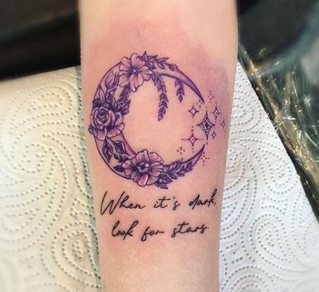 crescent moon with flowers and wording tattoo