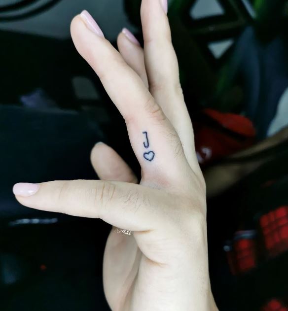 finger tattoo with letter J and a heart