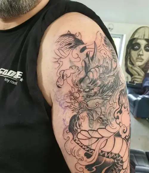 first session of a black and grey dragon tattoo