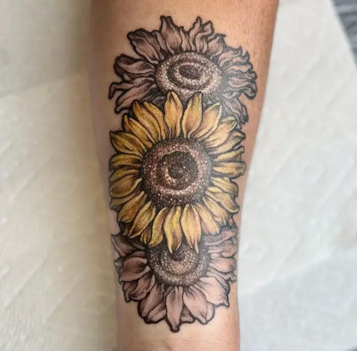 floral forearm tattoo with a little yellow