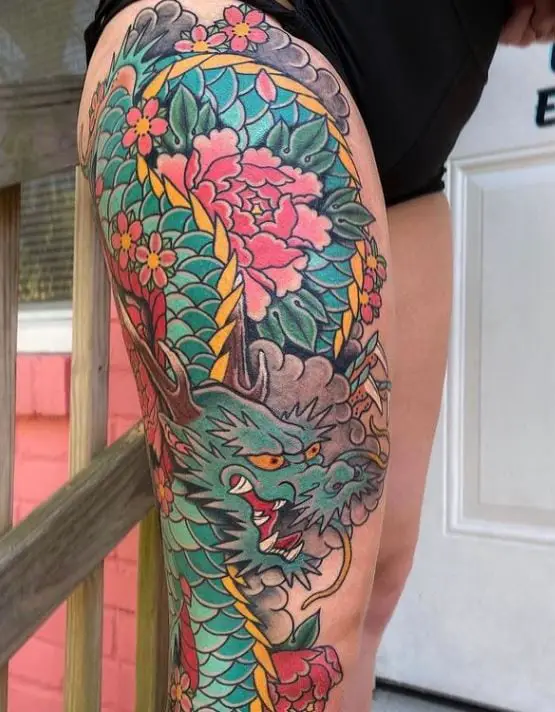 large coloful dragon tattoo on the thigh