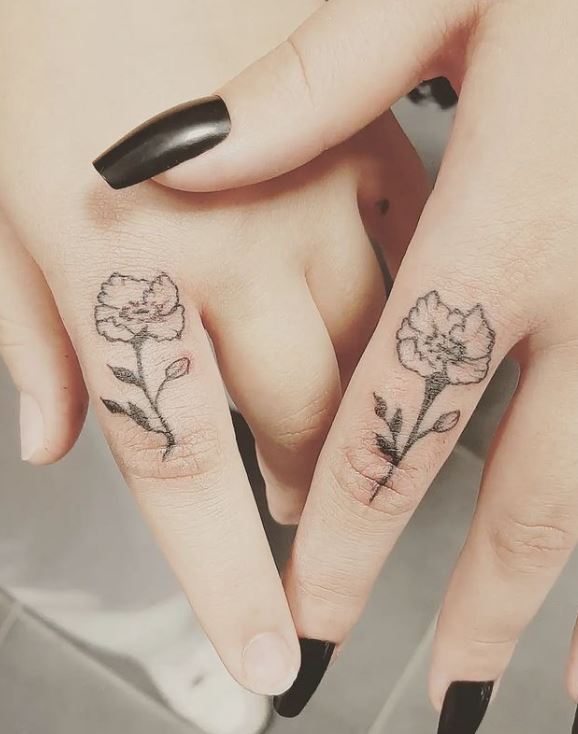 matching poppy flower tattoos on the fingers
