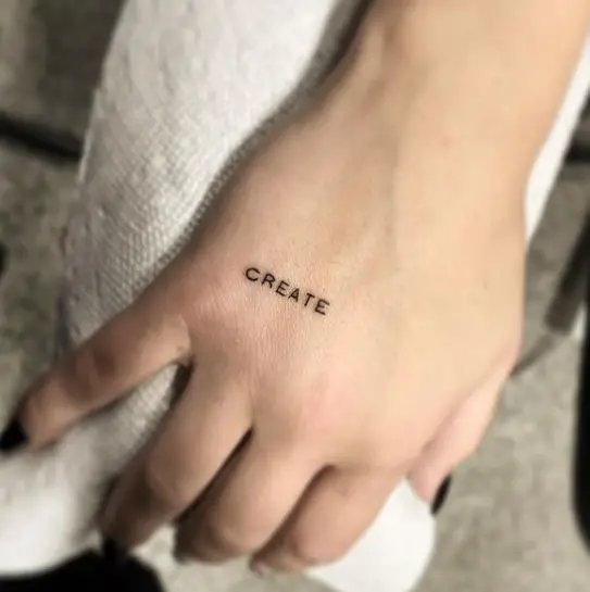minimal wording hand tattoo