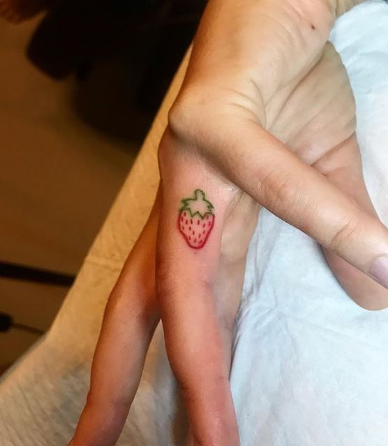 strawberry tattoo on the ring finger