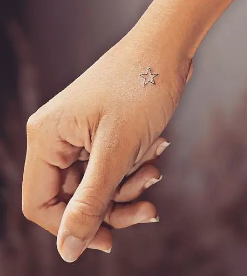 tiny star tattoo on the hand