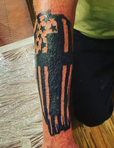 Large black cross tattoo on the forearm