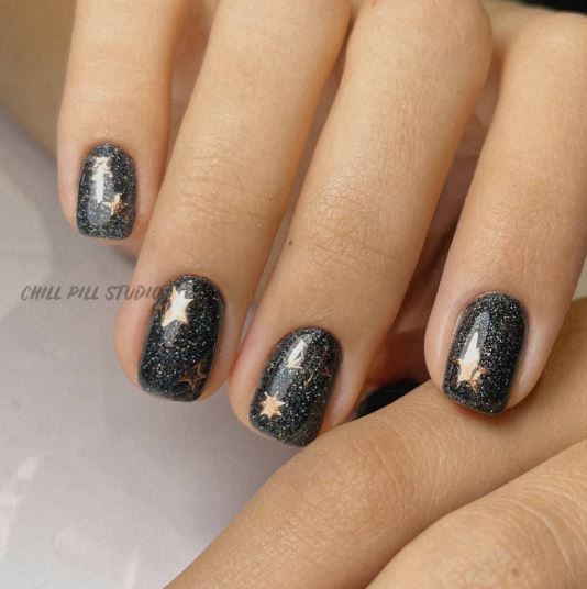 Black Glitter Nail Art with Gold Stars