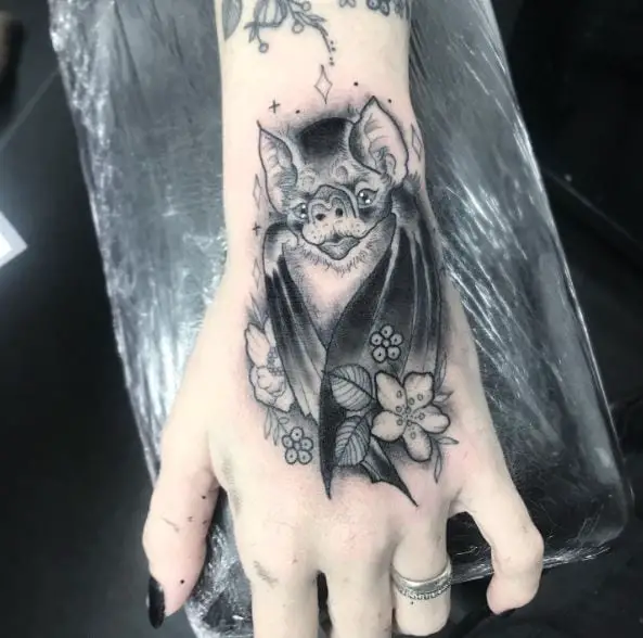 Flowers and Vampire Bat Hand Tattoo