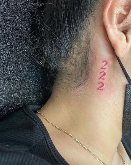 Number 222 tattoo located on the neck