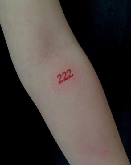 Number 222 tattoo located on the neck