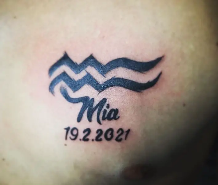 black ink tattoo with name and birthdate