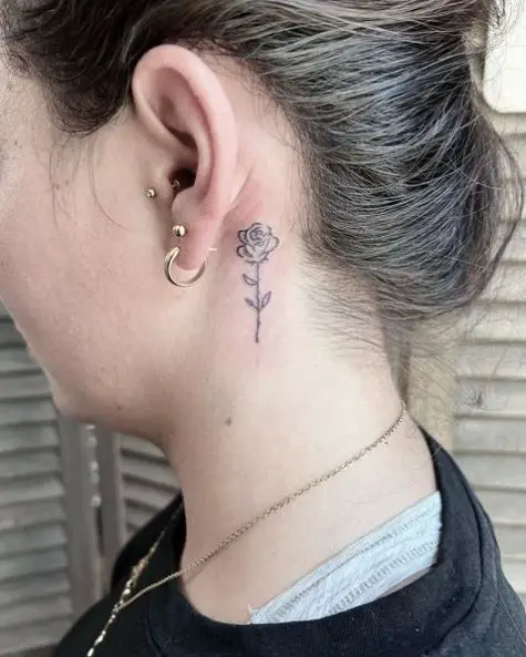 Single needle rose tattoo behind the right ear