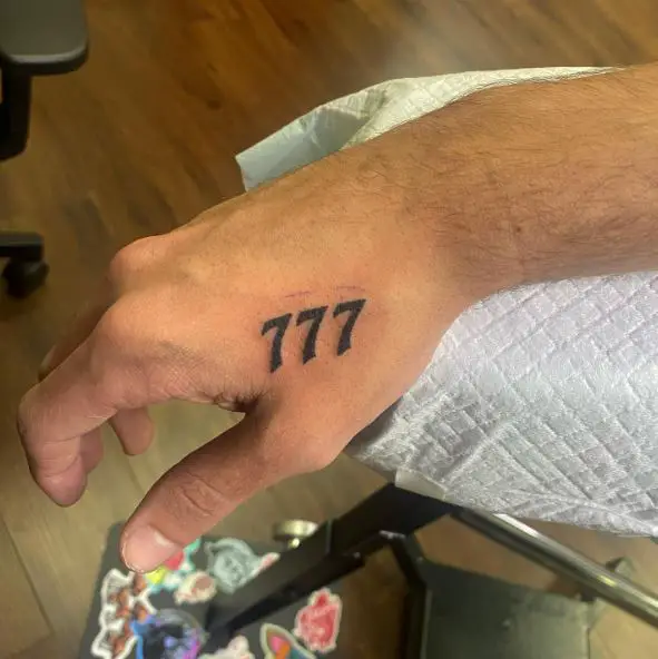 Minimalistic 777 Hand Tattoo