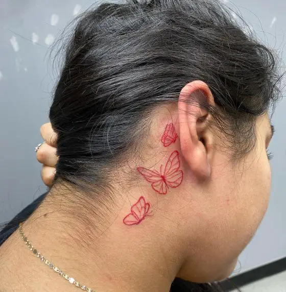 Minimalistic Red Butterflies behind Ear Tattoo