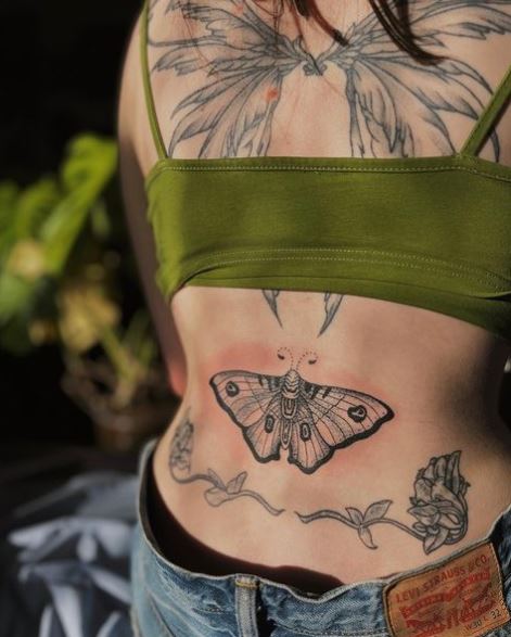 Grey Flowers Below Moth Back Tattoo