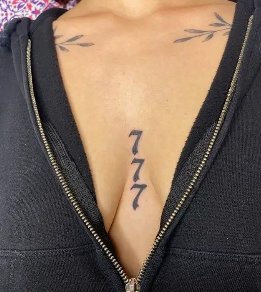 Black 777 between Breasts Tattoo