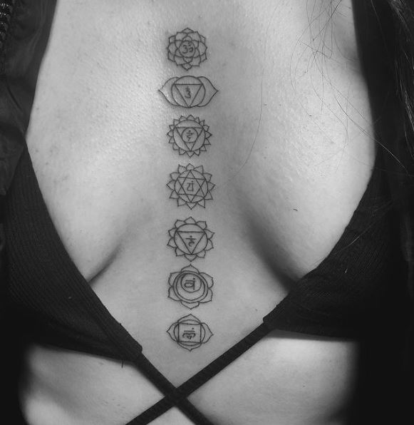 Chakra Symbols Between Brest Tattoo