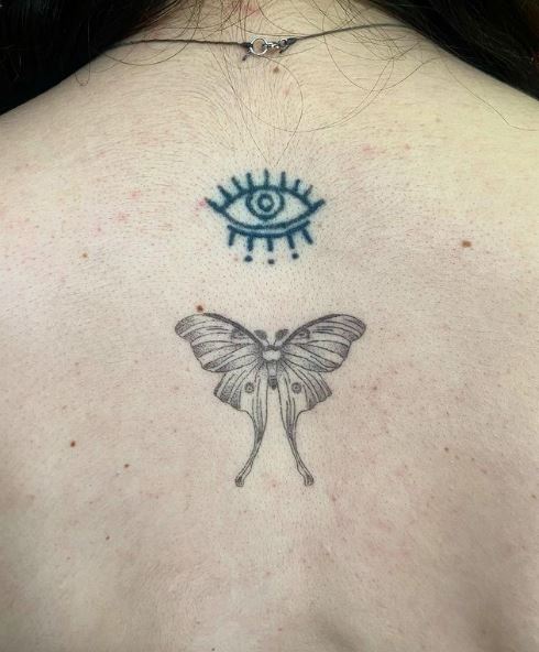 Blue Eye and Grey Moth Spine Tattoo