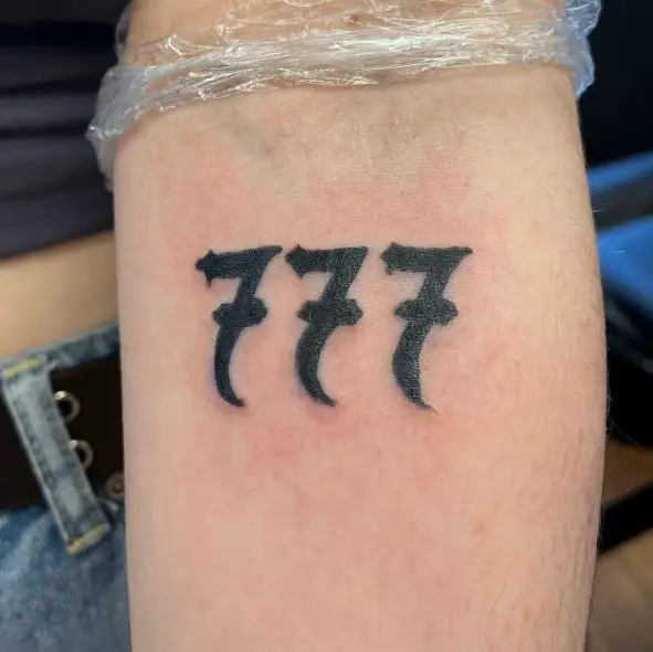 Bold 777 Forearm Tattoo