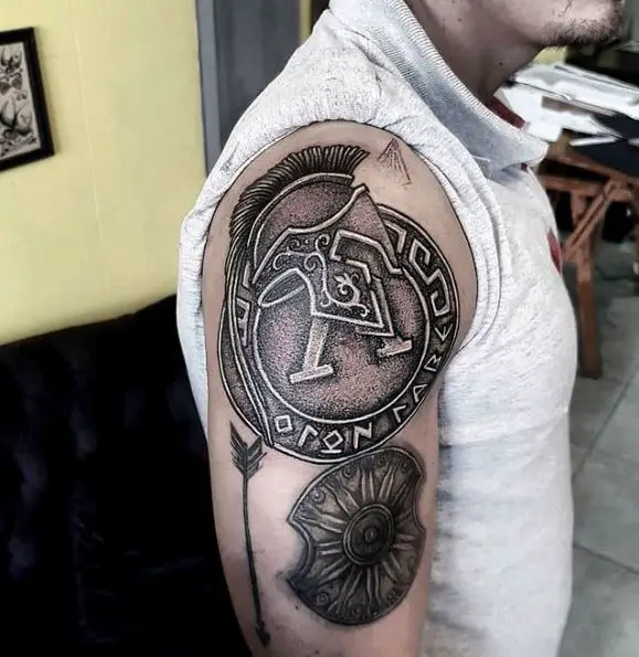 Single needle Spartan tattoo on the left shoulder.