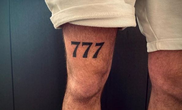 Black 777 above Knee Tattoo