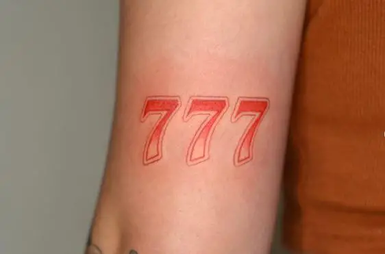 Red Colored 777 Biceps Tattoo