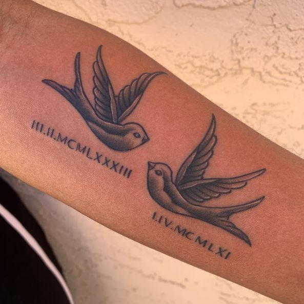 Roman Numbers Below Two Shaded Swallows Arm Tattoo