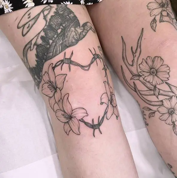 Lilies On Heart Shaped Barbed Wire Knee Tattoo