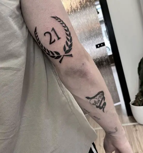 21 and Laurel Wreath Elbow Tattoo