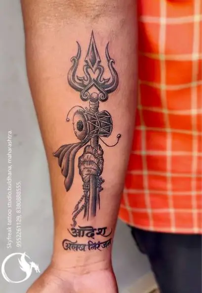 Grey Hand holding Trishul Forearm Tattoo