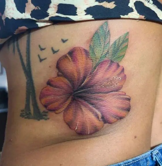 Colored Hawaiian Flower Tattoo on the Hip