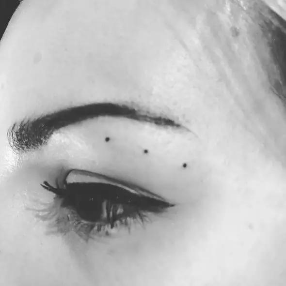 Three Dots Tattoo Below the Eyebrow