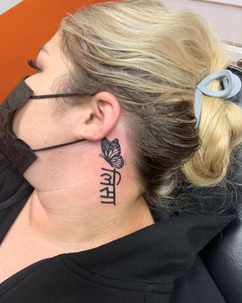 Black Butterfly with a Phrase Ear Tattoo