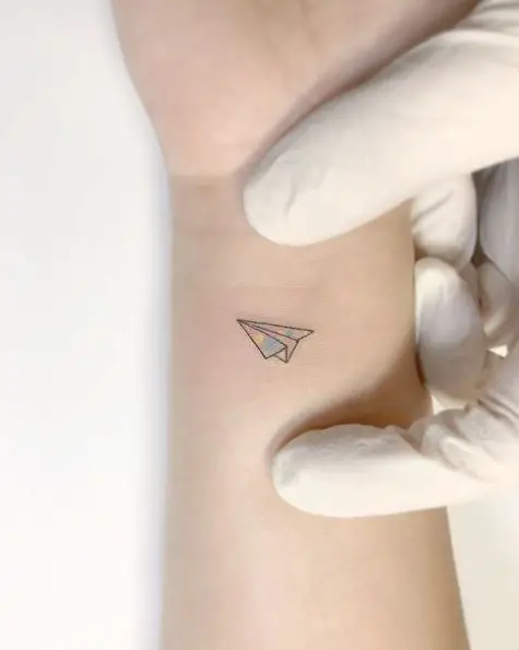 Tiny Rainbow Colored Paper Plane Tattoo