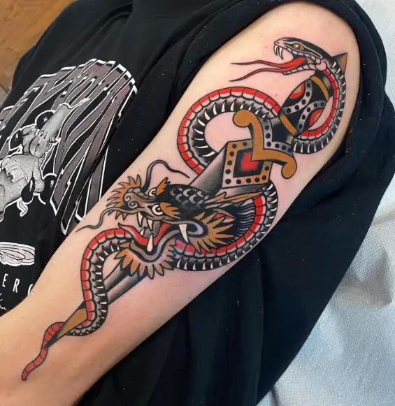Traditional style snake and dagger tattoo on the elbow.