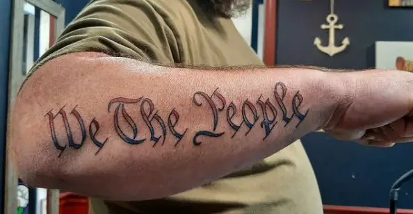 Black and Red Font We the People Forearm Tattoo