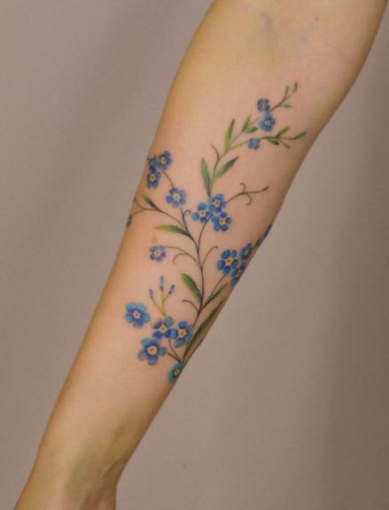 Blue Forget Me Nots and Green Leaves Forearm Tattoo