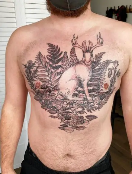 Tattoo of a Deer is Sitting in a Garden with Fern Leaves