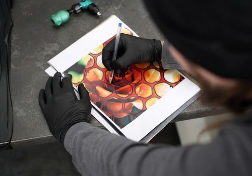Tattooist Designing a Colorful Tattoo on Paper