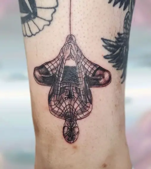 Black Hanging Upside Down Spiderman Ankle Tattoo