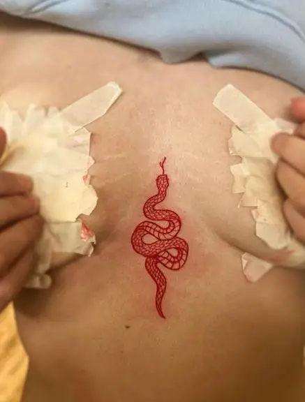 Red Ink Snake Sternum Tattoo