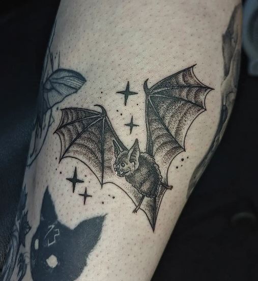 Grey Shaded Stars and Gothic Bat Arm Tattoo