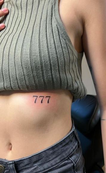 Black 777 Angel Number Ribs Tattoo